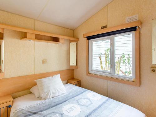 une petite chambre avec un lit et une fenêtre dans l'établissement Mobile Home in Var near Miramar Beach, cleaning included, à La Londe-les-Maures