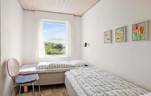 a bedroom with two beds and a window at Holiday Home Lundvej Sønderborg Xii in Vollerup