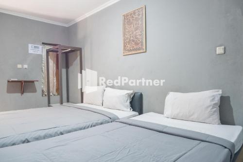Postel nebo postele na pokoji v ubytování Crown Residence Hotel near Tugu Yogyakarta Mitra RedDoorz