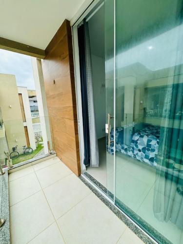 eine offene Glastür eines Hauses mit Balkon in der Unterkunft Casa brisa do mar in Arraial do Cabo