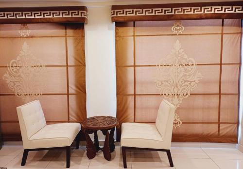 two chairs and a table in a room at Orient Heights in Ado Rāi
