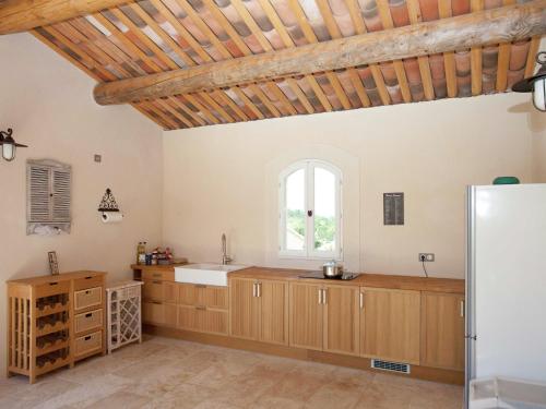 une grande cuisine avec des placards en bois et une fenêtre dans l'établissement Villa in Provence with Infinity Pool, cleaning included, à Martres-Tolosane