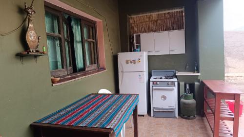 a kitchen with a refrigerator and a table in it at El MasSi in Tilcara