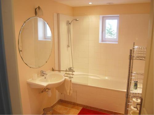 une salle de bain avec un lavabo, une baignoire et un miroir dans l'établissement Villa in Valréas with Pool and Garden Views, cleaning included, à Valréas