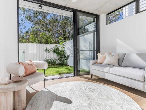 a living room with a couch and a table at Urbanstayz - Lakehouse No 4- Luxury Lakefront Getaway Villa Pet Friendly in Cabarita Beach