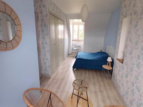 a bedroom with a blue bed and two chairs at Holiday Home in Port-Blanc near Sandy Beaches in Penvénan