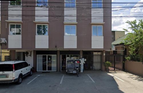 a building with a car parked in front of it at Good Shepherd Apartelle in Urdaneta