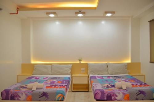 a room with two beds and a large window at Good Shepherd Apartelle in Urdaneta