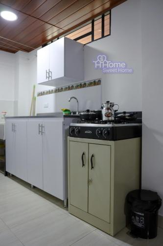 a kitchen with white cabinets and a black stove at Home Sweet Home in Pitalito