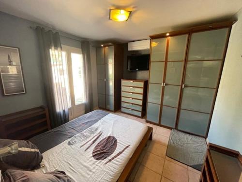 - une chambre avec un lit, une commode et une télévision dans l'établissement Villa in Vidauban with Pool & Vineyards Nearby, cleaning included, à Vidauban
