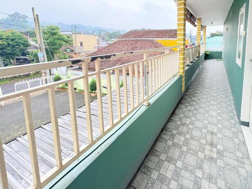 a balcony of a house with a wooden railing at RedDoorz Syariah at Nusa Indah near BNS in Batu