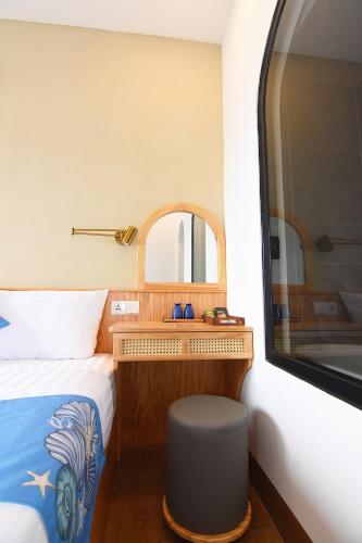 a small bedroom with a bed and a mirror at Sea Night - Sea Home Hotel in Phan Thiet