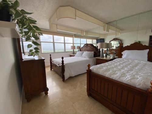 a bedroom with two beds and a large mirror at Downtown Isla Verde Beachfront Apartment with Pool and Parking in San Juan