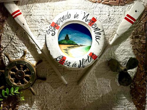 a sign on a wall with a picture of a beach at Casa de Mirtes in Fernando de Noronha