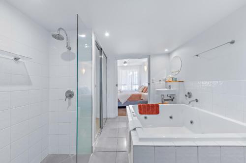 エアリービーチにあるBoho Delux with sea views , Pool+Gymの浴槽とシャワー付きの白いバスルーム