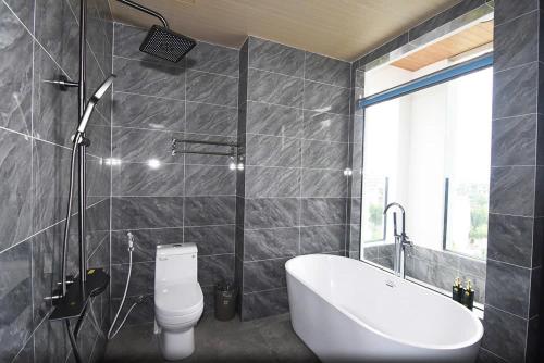 a bathroom with a tub and a toilet and a sink at Sea Night - Sea Home Hotel in Phan Thiet