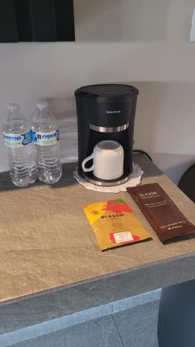 a counter with a coffee maker and water bottles at Real La Viga Motel in Mexico City