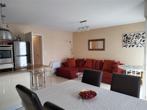 un salon avec un canapé rouge et une table dans l'établissement Duplex de Charme - Proche Plage, Port & Rues Piétonnes avec Parking Privé - FR-1-331-6, à Les Sables-dʼOlonne