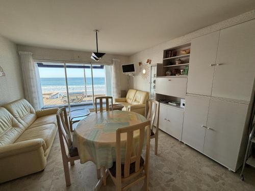 - un salon avec une table à manger et une vue sur la plage dans l'établissement Appartement T2 avec balcon et vue mer, 1er étage, ascenseur, TV, cuisine équipée - FR-1-197-466, à Les Sables-dʼOlonne