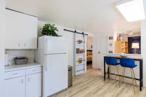 a kitchen with a white refrigerator and blue chairs at Quiet City Retreat Near Light Rail, Downtown & Stadiums! in Seattle
