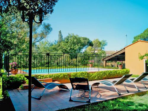 - un ensemble de chaises assises sur une terrasse avec piscine dans l'établissement Holiday Home in Fréjus near Sea and Lake, cleaning included, à Fréjus