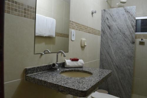 a bathroom with a granite sink and a shower at Richard Hotel in Porto Velho