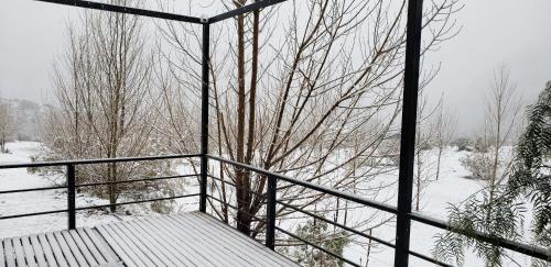 a room with a fence and a tree in the snow at Entre Montañas - Vista Calma in Potrerillos