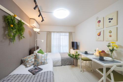 a hotel room with a bed and a desk with a computer at Home Tokyo Takinogawa in Tokyo