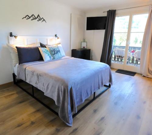 a bedroom with a large bed with blue pillows at Charming Studio - Ferienwohnung - Vulpera, Scuol in Scuol