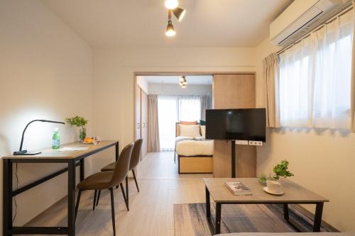 a living room with a table and a television in a room at Composite Omori in Tokyo