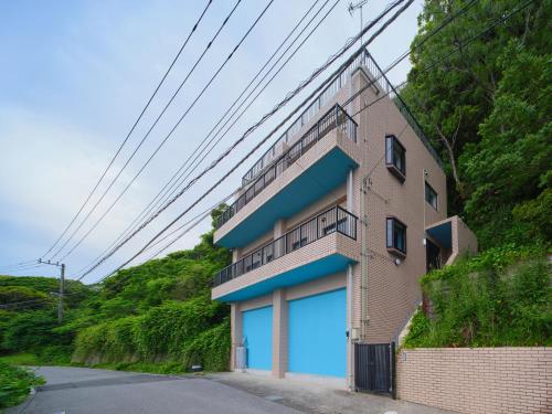a building with a blue door on the side of it at Kamogawa Sunset Villa - 鴨川サンセットヴィラ in Kamogawa