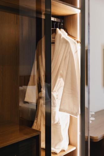 a closet with white towels hanging on a rack at Grand Duka Hotel & SPA in Durrës