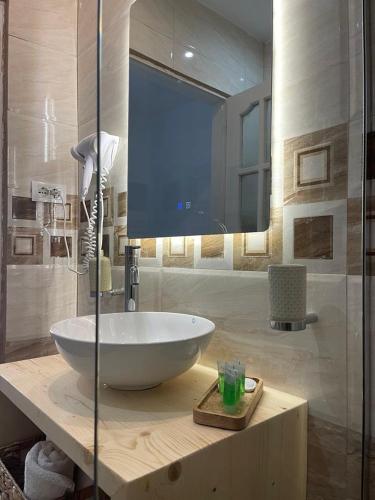 a bathroom with a sink and a large mirror at Enopia Apartments Himara in Himare