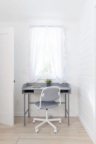 a desk with a chair in a room with a window at Tranquility Pond Cottage, Relax, Fish and Unwind in Buford