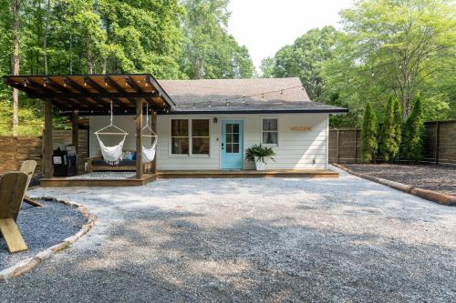 a small white house with a pergola at Tranquility Pond Cottage, Relax, Fish and Unwind in Buford