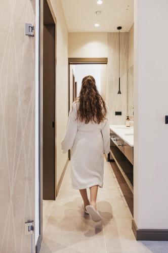 a woman walking down a hallway in a bathroom at Grand Duka Hotel & SPA in Durrës