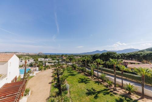 an aerial view of a resort with palm trees at Hotel Corsica & Spa Serena in Calvi