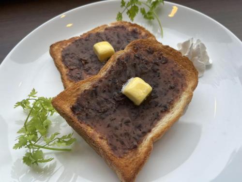 a white plate with two pieces of bread with butter at Dormy Inn Premium Nagoya Sakae in Nagoya