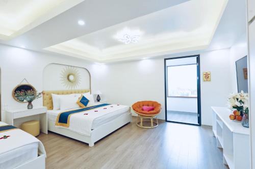 a white bedroom with a bed and a table at Mia Noi Bai Airport Hotel in Noi Bai