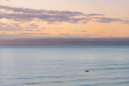 a boat in the ocean under a cloudy sky at Surfwatch House in Kaikoura