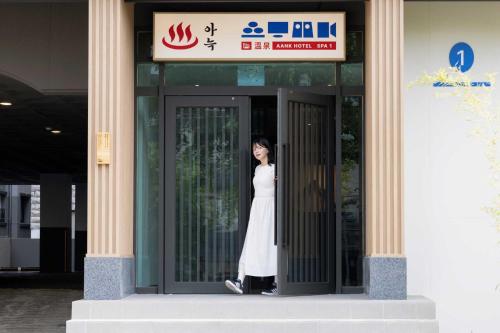 a woman standing in the doorway of a building at Aank Hotel and Spa Daejeon Yuseong in Daejeon
