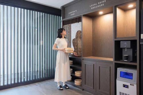 a woman is standing in a dressing room at Aank Hotel and Spa Daejeon Yuseong in Daejeon