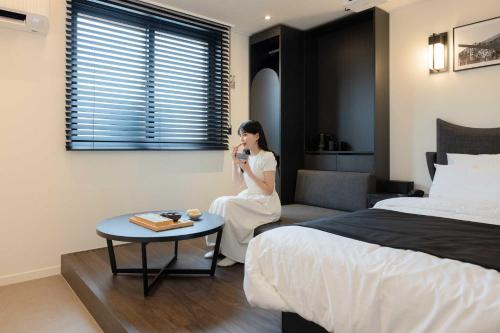 a woman taking a picture of a hotel room at Aank Hotel and Spa Daejeon Yuseong in Daejeon