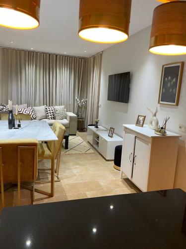ein Wohnzimmer mit Couch und Tisch in der Unterkunft Beautiful apartment with pool in Mansouria