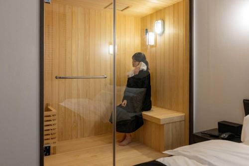 a woman standing in a shower in a room at Aank Hotel and Spa Daejeon Yuseong in Daejeon