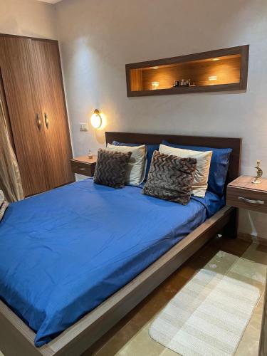 ein Schlafzimmer mit einem blauen Bett mit zwei Kissen in der Unterkunft Beautiful apartment with pool in Mansouria
