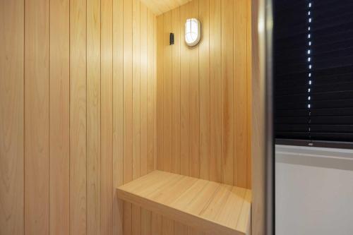 a small sauna with a clock on a wooden wall at Aank Hotel and Spa Daejeon Yuseong in Daejeon