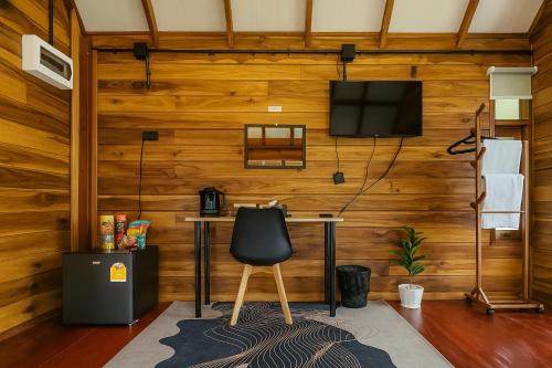 a room with a desk and a tv on a wall at Nalintara resort นลินธารารีสอร์ท in Ban Pha Saeng Lang