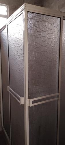 a glass shower door in a bathroom at Habitaciones cerca al aeropuerto& alojamiento &apartaestudio in Palmira