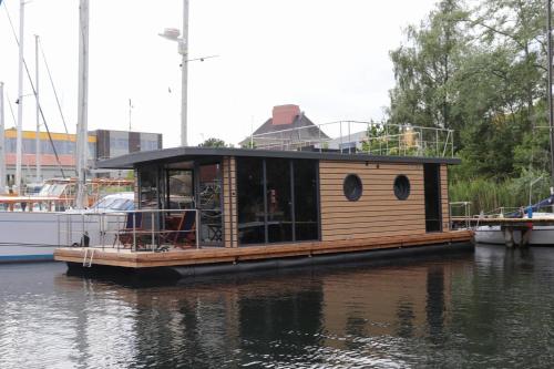 ein kleines Haus auf einer Anlegestelle im Wasser in der Unterkunft Houseboat Leni, Flensburg in Flensburg